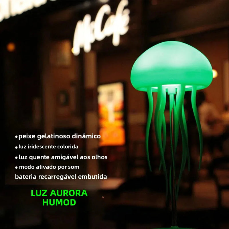 Luminária de cabeceira LED em formato de água-viva, com cores RGB ajustáveis, tentáculos ativos e recarregável via USB, base polida.