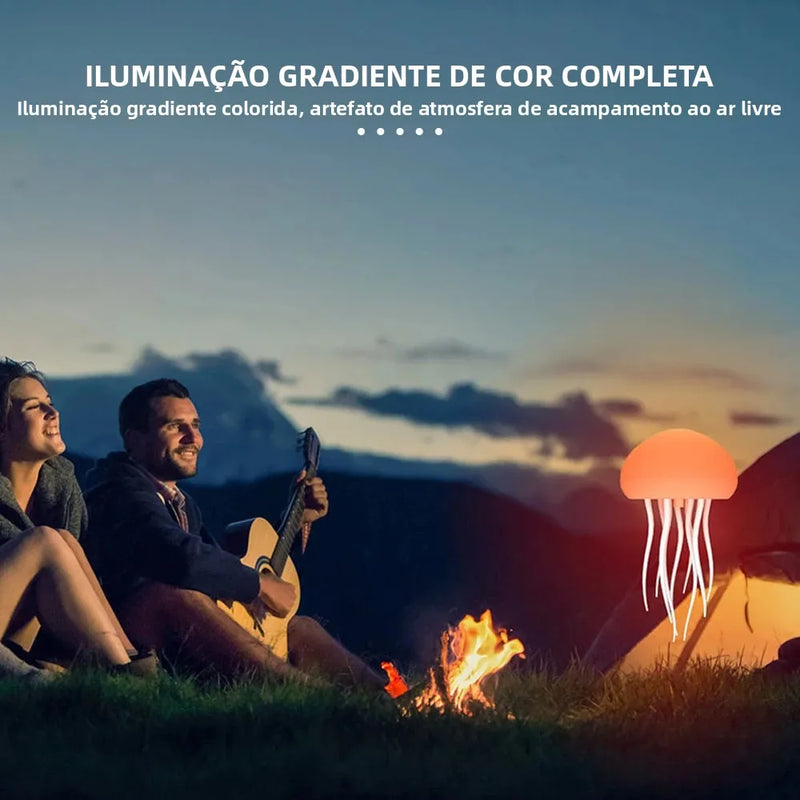Luminária de cabeceira LED em formato de água-viva, com cores RGB ajustáveis, tentáculos ativos e recarregável via USB, base polida.