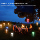 Luminária de cabeceira LED em formato de água-viva, com cores RGB ajustáveis, tentáculos ativos e recarregável via USB, base polida.